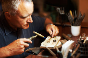 Jeweler using a blowtorch while he works on a ring